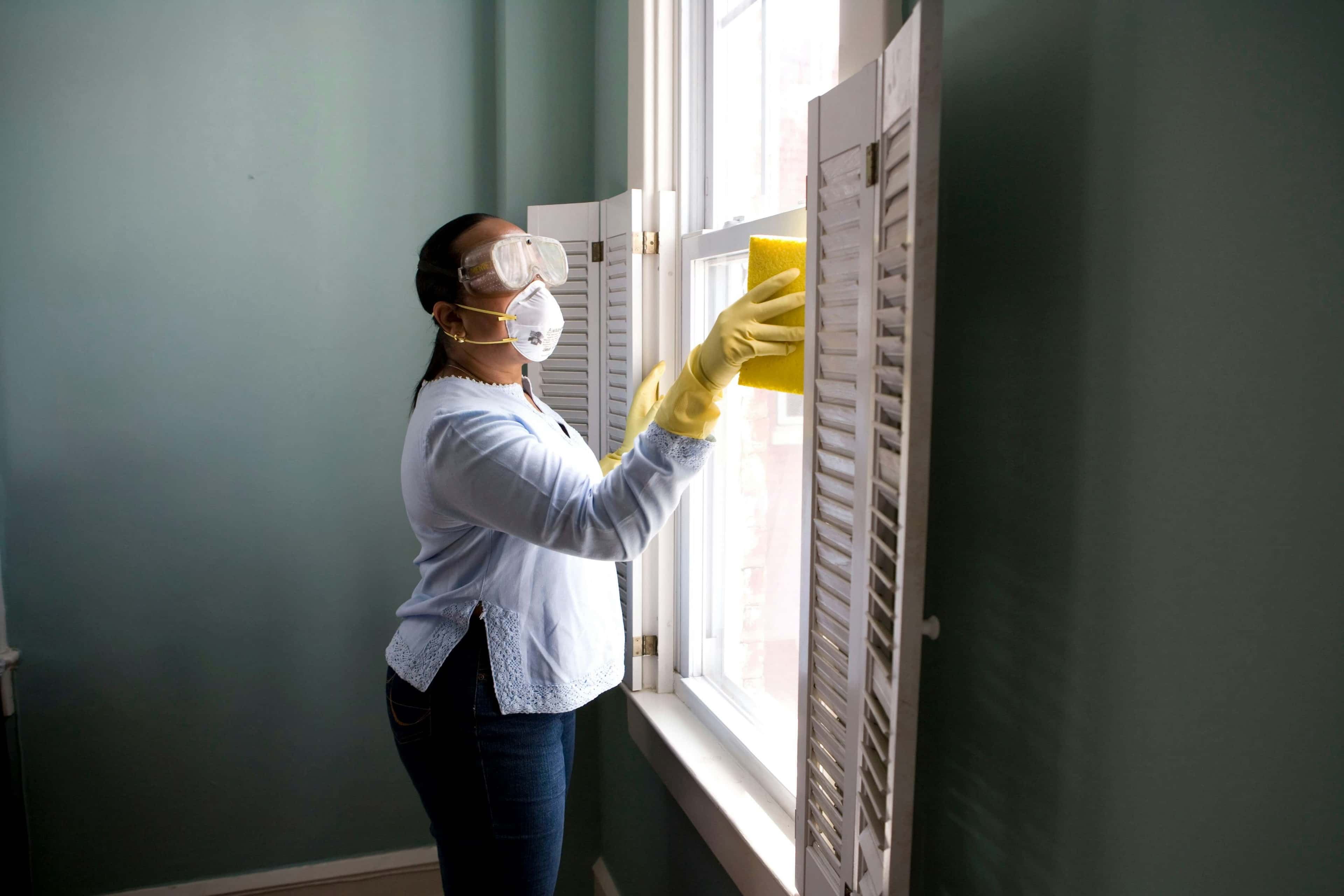 A professional cleaning a window during a turnover cleaning service